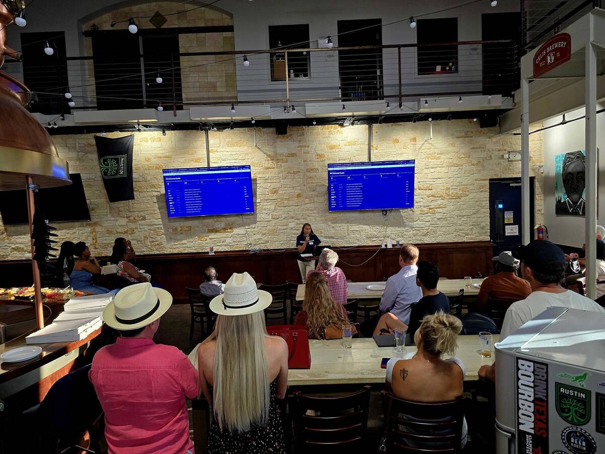 A presenter walking the room through a live product on two screens