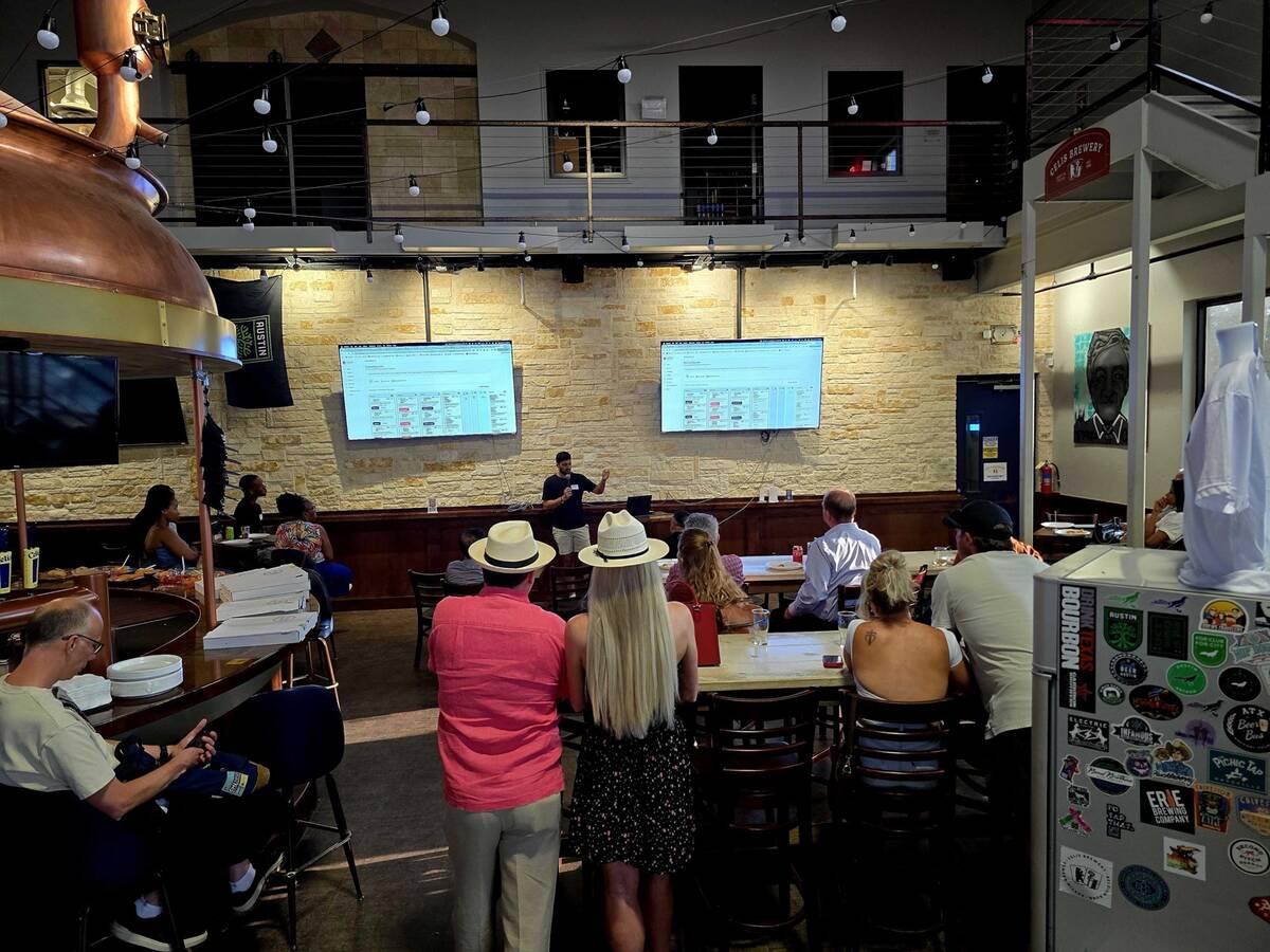 Audience watching a live demo on two screens at an Austin brewery